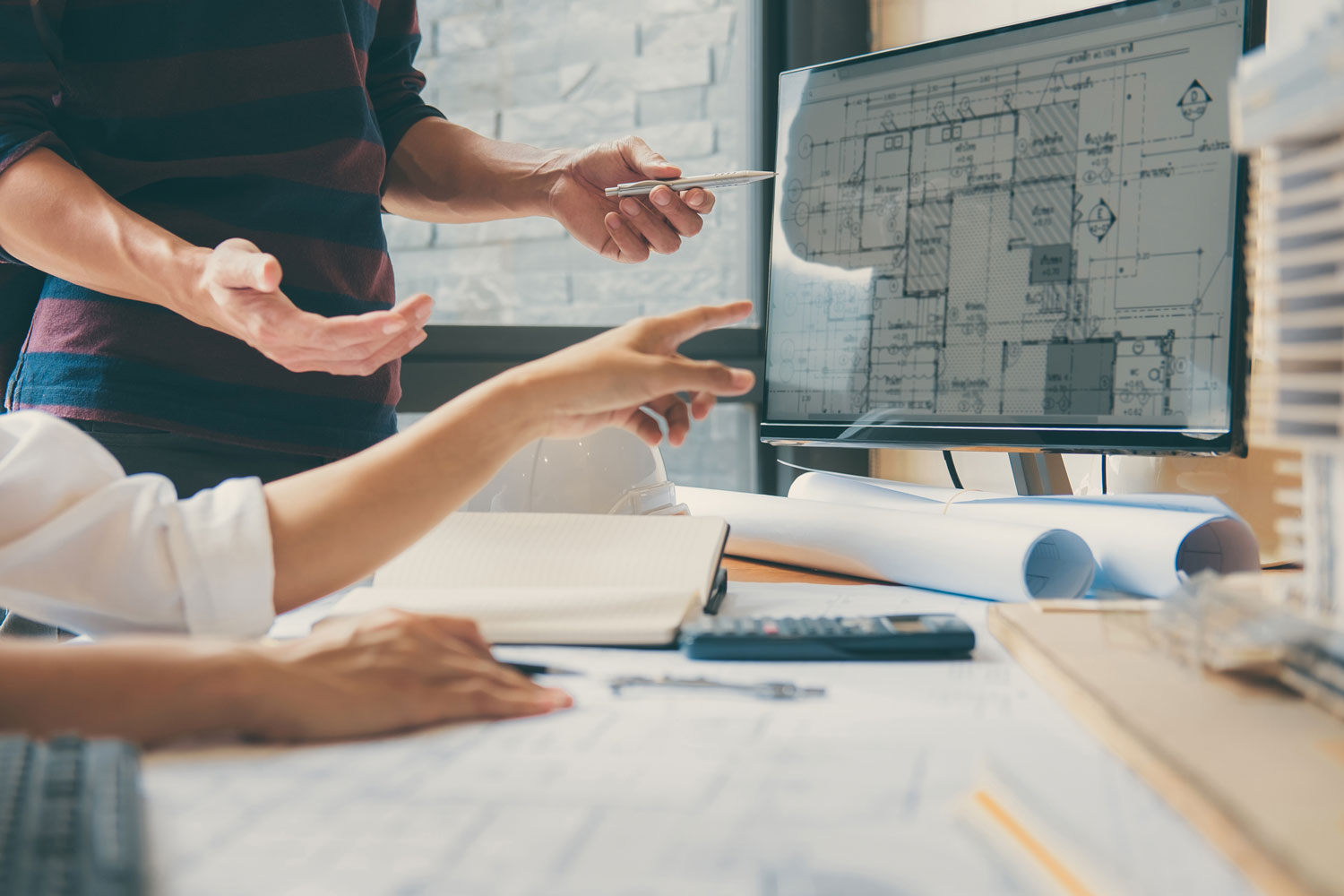 Architekten schauen auf einen Bauplan am Bildschirm.